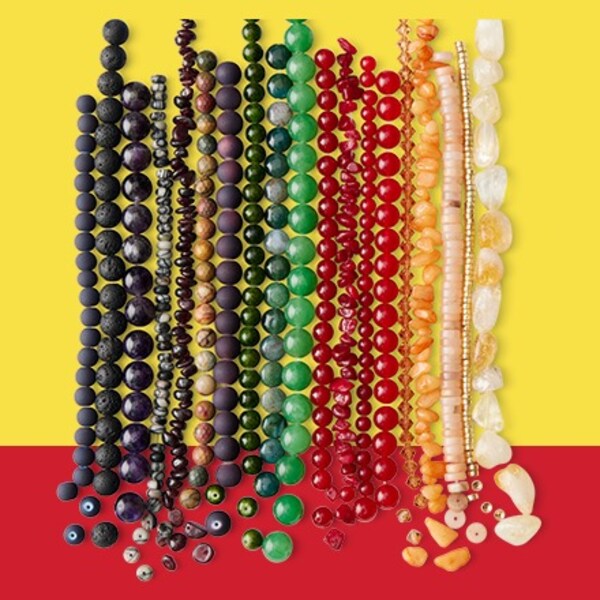assorted beads lined up in various colors and sizes on yellow and red background